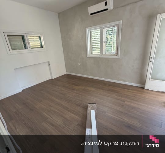 חדר עם פרקט עץ ומזגן על הקיר